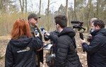 Na zdjęciu są widoczne osoby podczas konferencji, są widoczni leśnicy oraz dziennikarze, w tle są widoczne drzewa/ Fot. Kamil Czech