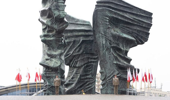 Na zdjęciu jest widoczna delegacja leśników, mężczyźni stoją przed pomnikiem Powstańców Śląskich w Katowicach/ Fot. Martyna Majda