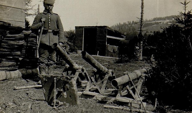 Na czarno-białym zdjęciu widać żołnierza armii niemieckiej w czasów pierwszej wojny światowej stojącego przy zdobytej broni/ Zbiory R. Eryka
