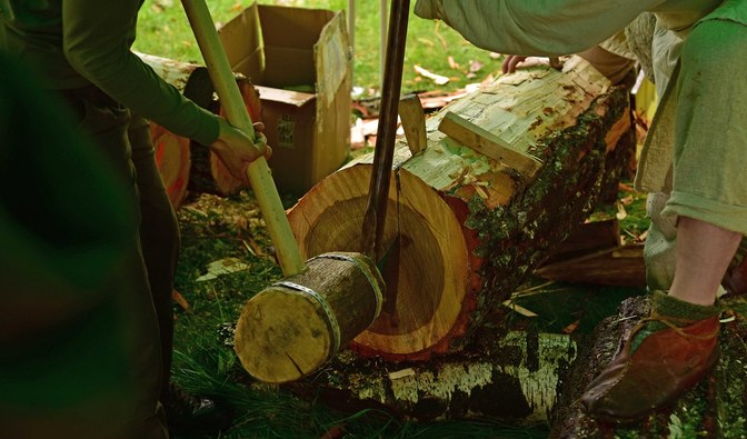Fotografia przedstawia rozłupywanie drewna.