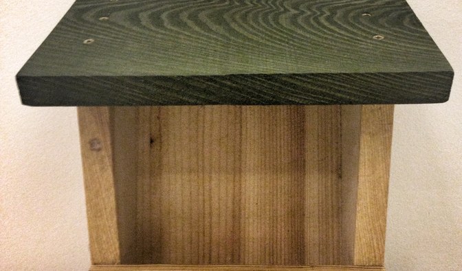 Przykład karmnika jednostronnego, z dodatkową listwą mocującą z tyłu. Nadaje się do powieszenie na ścianie budynku lub do pnia drzewa.