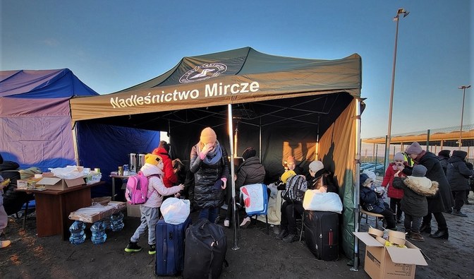 Na zdjęciu są widoczne dzieci oraz kobiety stojące obok namiotu z napisem Nadleśnictwo Mircze/ Fot. Paweł Kurzyna