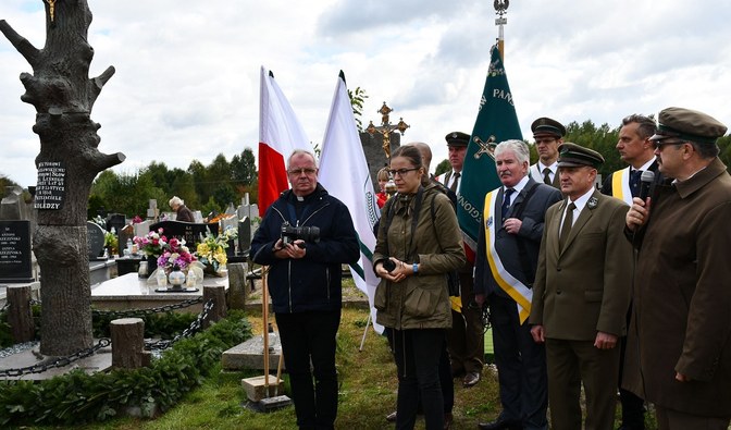 Fotografia przedstawia osoby zebrane przy pomniku Wiktora Kozłowskiego