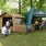 Przed drewnianym domkiem z napisem "Nadleśnictwo Chojnów" czekają ludzie. Obok domku znajduje się zielony namiot wystawowy Nadleśnictwa Chojnów, pod którym widać osoby biorące udział w warsztatach.